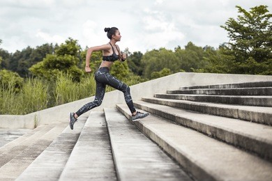 asian woman sport woman running upstairs on city stairs