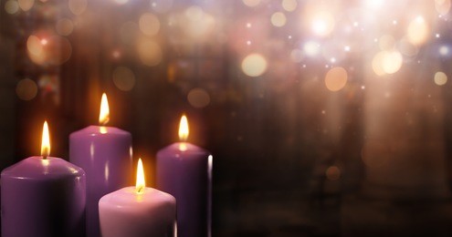 advent candles in church - three purple and one pink as a catholic symbol
