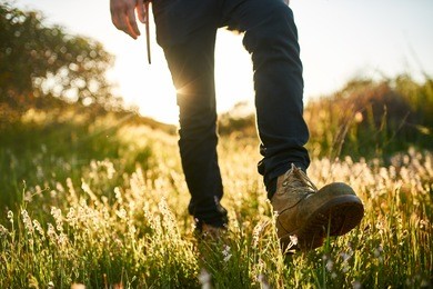 close up of hikers boot while walking through grass during hike