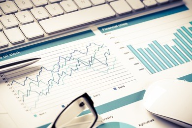 business workplace with keyboard mouse and papers with graphs and diagrams