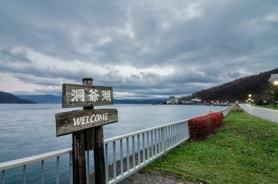 cloudy view of the infamous lake toya. the lake is a volcanic caldera lake in shikotsu-toya national park, located in hokkaid, japan. text on signboard read as "lake toya"