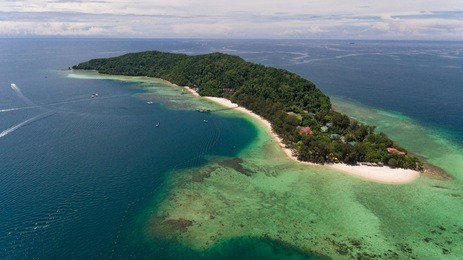 an aerial view manukan island resort. this serene retreat offers exquisite accommodation, sophisticated cuisine and unparalleled watersport activities in one of the most pristine corner of the world.