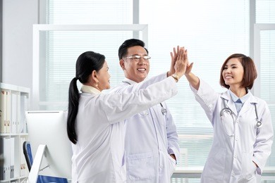 team of doctor giving high five after successful day of work