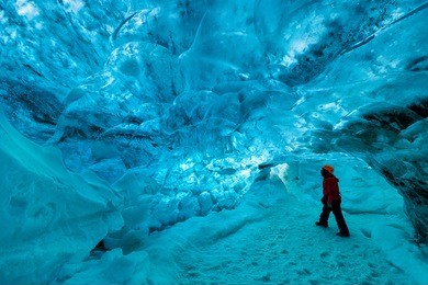 explorer inside an ice cave, skaftafell glacier, vatnajokull national park, iceland