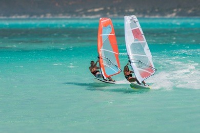couple windsurfers in the lagoon of emerald sea, antsiranana bay (diego suarez), madagascar.