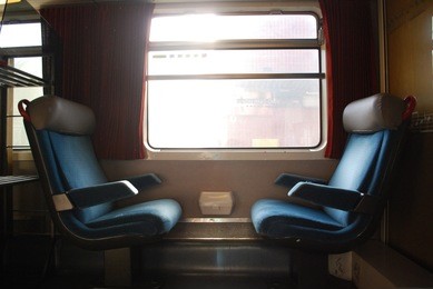 2 vintage train chairs facing each other with window
