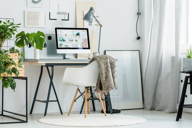 white poster on floor and patterned curtain in scandinavian style workspace with plants