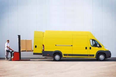 package delivery, courier is loading the van with parcels.