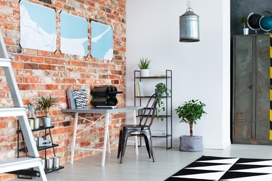 fresh green potted plants placed in modern industrial loft with desk and handmade lampshade