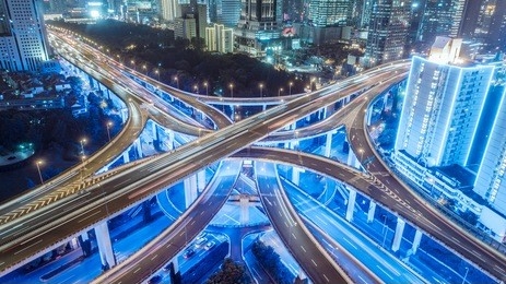 aerial view of buildings and highway interchange at night in shanghai city
