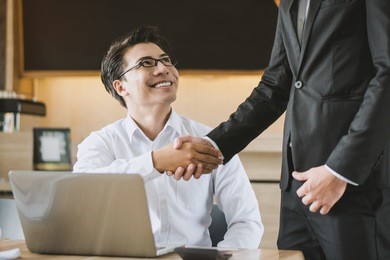 two asian businessmen shaking hands in the meeting, business partnership concept.