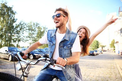 happy funny young couple riding on bicycle. love, relationship, romance concept.