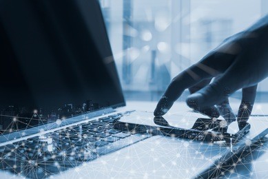 business man touching mobile smart phone screen and working on laptop computer in blue tone with internet network technology connection, data transfer, futuristic internet of things, iot concept