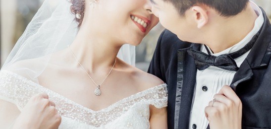asian groom and asian bride are close together and are about to kiss each other with a smiling and happy face.