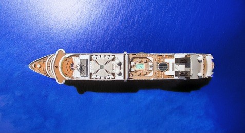 aerial view of luxury cruise ship at blue ocean, top down view of swimming pool and deck