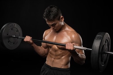 muscular asian shirtless man lifting barbell isolated on black 