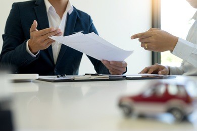 young business man insurance agent and customer look at the contract together at the table in office