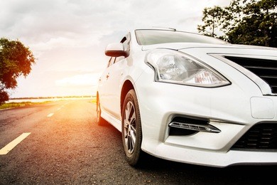 carblonde traveling in nature on an asphalt road - front view