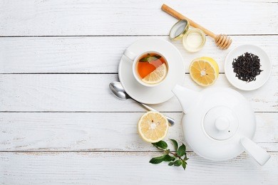 composition of black tea with lemon, honey and mint on a white background.top view.