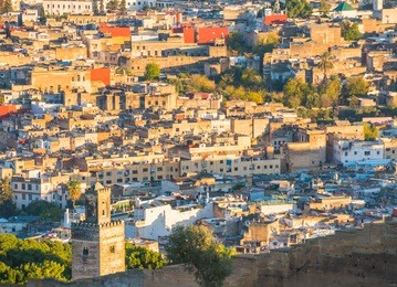 view of fez medina in morocco from above on sunset with houses, streets and mosques with soft focus