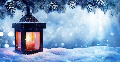 christmas lantern on snow with fir branch in evening scene