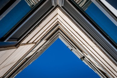 urban geometry, looking up to building. modern architecture with concrete and glass blue sky background.  abstract architectural design. inspirational. artistic image and point of view.