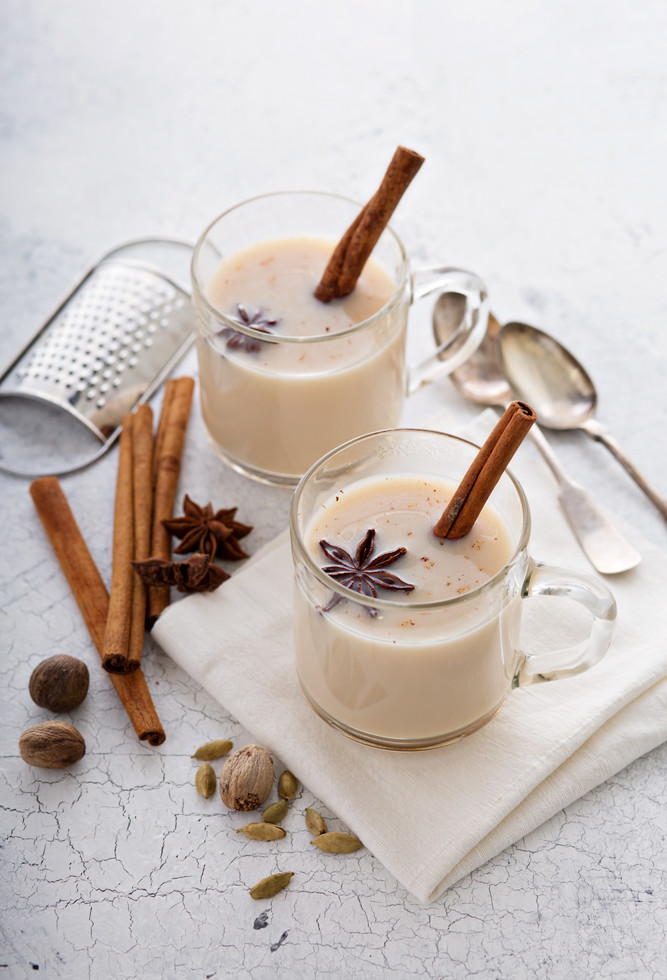 warm chai tea with milk and winter spices in glass mugs