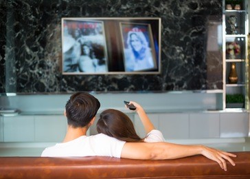 young asian couple in sweet moment, relax and   watching television in living room.