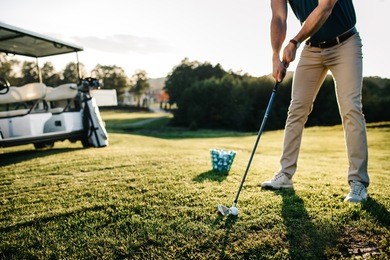 man playing golf on a golf course in the sun