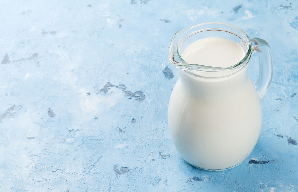 milk jug on stone table. dairy products. view with copy space