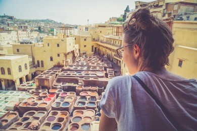 happy tourist girl watching the typical tannery in the middle of souk of fez