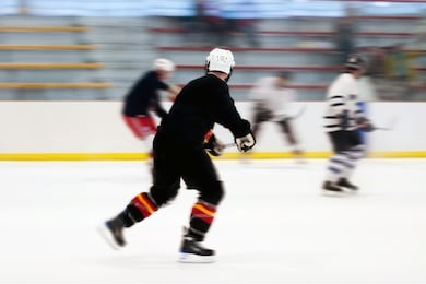 panned motion blur of two hockey players skating down the ice rink.  shallow depth of field.
