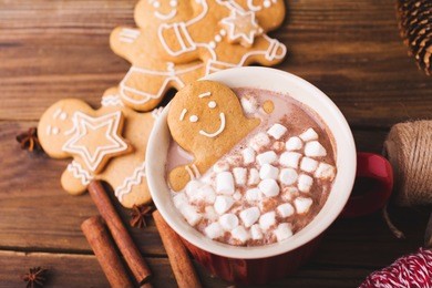 gingerbread man bathes in a cup of hot chocolate or cocoa with marshmallow. 