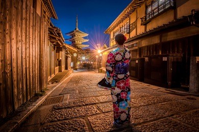the main image focus at the yasaka pagoda and sannen zaka street in kyoto, with foreground of blurred young women wearing traditional japanese kimono.