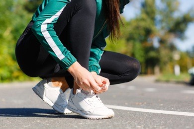 girl ties up shoelaces on sneakers
