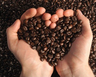 heart of cofee grains in hollow of the hand