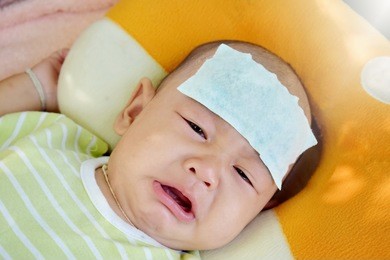 the baby is feverish and crying. relieve heat in infants with fever. selective focus.