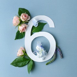 beautiful floral composition with number six made of paper on color background
