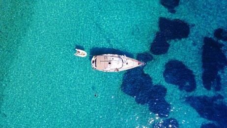 aerial bird's eye view photo taken by drone of tropical rocky seascape with yachts docked and turquoise - sapphire clear waters