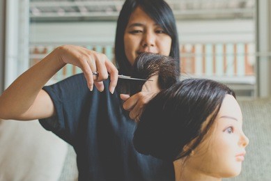 beautician practice close up of a hairdresser trimming the split ends