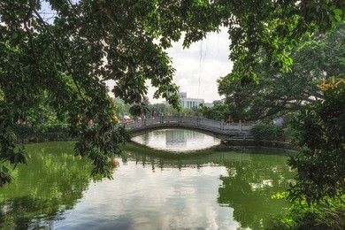 liuhuahu park with a small bridge reflecting on the lake water. taken in guangzhou, china