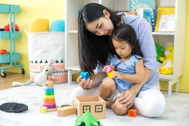 asian mother and daughter playing toy in house