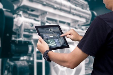 smart industry control concept.hands holding tablet on blurred automation machine as background