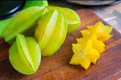 exotic  starfruit  or averrhoa carambola on wooden cut board. healthy food, fresh organic star apple fruit. carambolas background