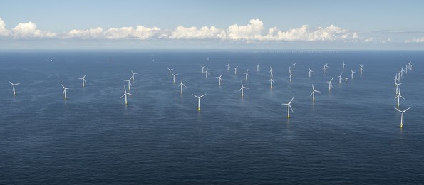 aerial view of off shore windpark luchterduinen. the windmills are in the noordzee, 20 kilometers from the dutch coastline between noordwijk and zandvoort. on the clear horizon a beautiful cloudstreet