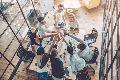 top view of multiracial young creative people in modern office. group of young business people are working together with laptop, tablet, smart phone, notebook. successful hipster team in coworking. 