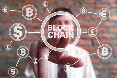 cryptocurrency blockchain and bitcoin concept. businessman presses currencies button block chain on  virtual electronic user interface.