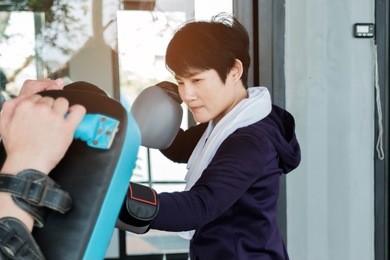 asian handsome sportman who has perfect body training women to exercise by boxing with boxing gloves at gym,box fighters training sport concept