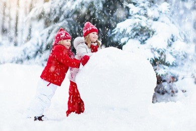 children build snowman. kids building snow man playing outdoors on sunny snowy winter day. outdoor family fun on christmas vacation. boy and girl play snow balls. winter clothing for baby and toddler.