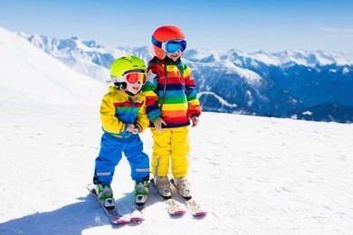 child skiing in the mountains. kid in ski school. winter sport for kids. family christmas vacation in the alps. children learn downhill skiing. alpine ski lesson for boy and girl. outdoor snow fun.